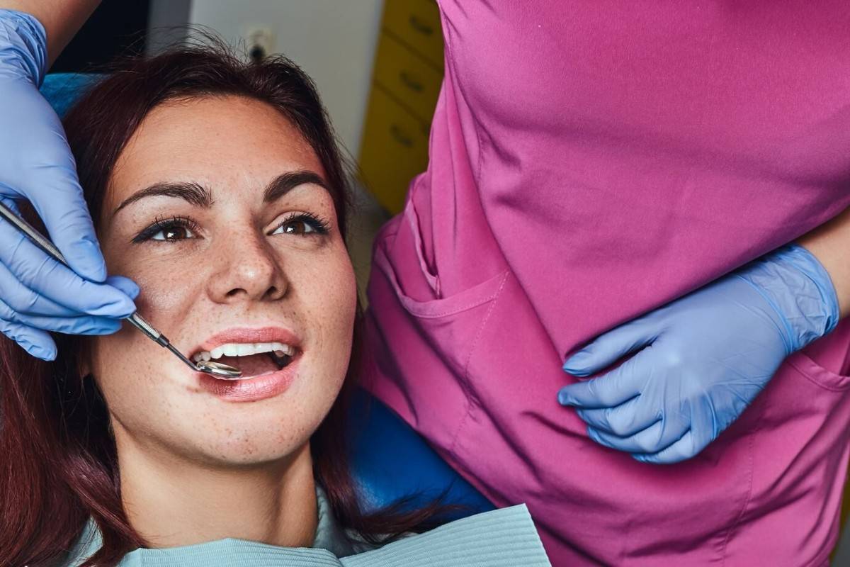 Female patient receiving dental cleaning from dentist